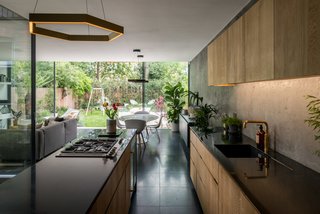 Arranged in an open plan with dark, terrazzo-tiled flooring, the main living space consists of the kitchen, dining area, and living room. 