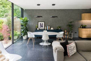 A wall of polished plaster extends to the rear, accentuating the ceiling height and adding a raw, textured finish to the otherwise polished interior space. 