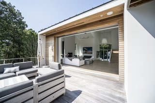 Collapsing walls were added to expand the open-plan living space on the main floor. This extended the space into an outdoor deck, which can now be enjoyed all summer long.