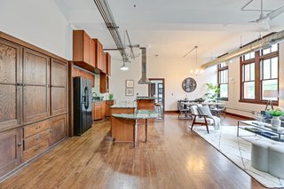 The open-plan kitchen, dining, and living rooms are big and bright with high ceilings, large windows, and lots of storage space repurposed from the original school. 