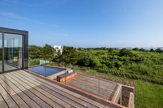 An expansive outdoor deck features a spacious gunite swimming pool, spa, and pool house with an outdoor shower—all of which add to the home's resort-like feel. 