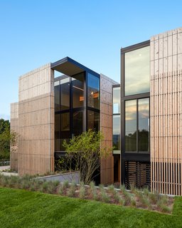 The exterior of the home is layered for privacy and shade. Alaskan cedar siding adds an elegant and dramatic modern touch. 
