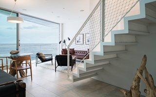 Angled balconies at the first and second levels are accessed by floor-to-ceiling sliding doors, enhancing the indoor/outdoor living experience and allowing natural ventilation. 