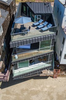 Standing-seam siding folds up from the street façade over the roofline to the roof deck, creating a seamless transition between wall and roof. 