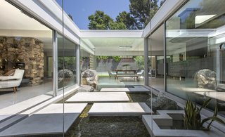 The home features a gorgeous glass atrium at its center that invites light to flood the interiors.