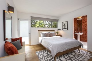 This bedroom features a beautifully tiled bathroom. 