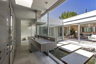 The modern, stainless-steel kitchen also fully opens to the atrium.