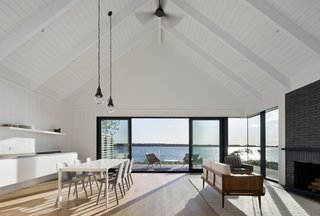 The great room of the guesthouse is also set at the ground level, and features expanses of glass that provide stunning views and allows for easy indoor/outdoor living. 