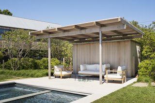A covered sitting area at the edge of the pool. 