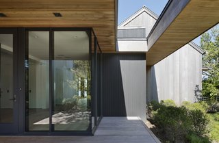 The overall rustic exterior is juxtaposed against a modern entry with a sleek profile. 