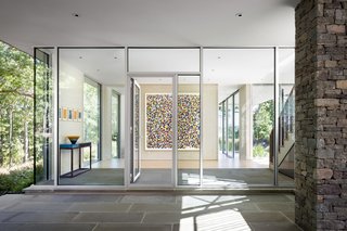 The extensive use of glazing on the first floor of the home allows light to enter, and also creates a strong sense of the surrounding nature preserve inside the living space. 