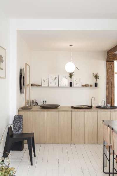 Benichou opened the space up by removing a wall and integrating the kitchen with the dining room. She then inserted a wooden counter that can now serve as a buffet when the gallery hosts dinners and events.