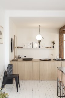 Benichou opened the space up by removing a wall and integrating the kitchen with the dining room. She then inserted a wooden counter that can now serve as a buffet when the gallery hosts dinners and events.