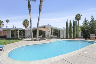 The lot is almost 10,000 square feet, and the fully enclosed backyard space is perfect for entertaining and features a kidney-shaped swimming pool and a hot tub.