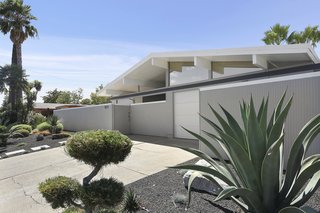 The meticulously landscaped front yard is low-maintenance and features drought-tolerant plants and a sprinkler system for an authentic Palm Springs vibe.
