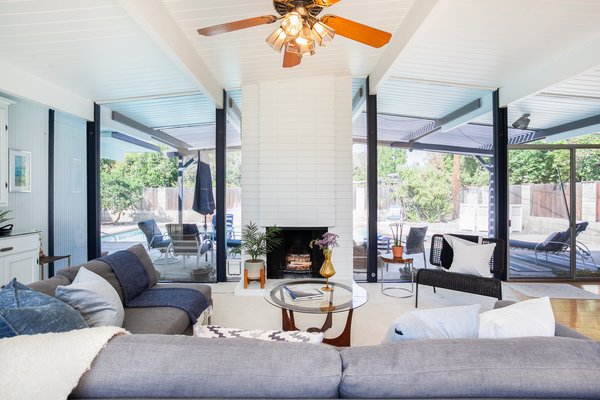 The home features an open-plan layout with a brick fireplace to anchor the space—a classic Eichler convention.