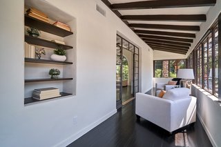 The bright sunroom has wraparound windows and is flooded with natural light. 