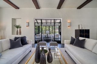 The living room opens to an airy enclosed sunroom.