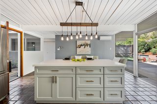 The expansive glazing in the kitchen brings both natural light and a sense of the outdoors into the space.