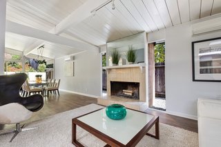 The wood-burning fireplace has been inserted between two glass panels. 