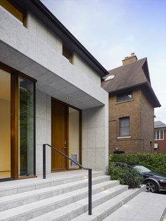 The dormers are clad in a modern zinc siding and jut out from a traditional pitched roof. Here, the Cenia Azul limestone façade feels restrained, yet still fits into the context of the more traditional neighborhood that surrounds it. The stone has been bush-hammered for a lighter finish and an almost suede-like texture, which complements the sleek dormers and custom mahogany windows and doors. 
