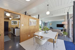 Original details include warm mahogany paneling and period-specific VCT tile throughout. 