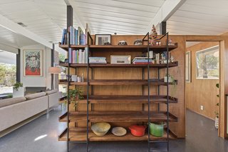 A bookshelf divider separates the kitchen from the dining room, while also adding storage. 