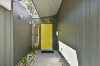 The front door has been painted yellow for a playful pop of color. 