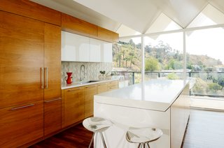 Wood paneling is set against the white cabinets and kitchen island. 