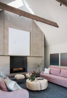 Rich, barn-like wooden beams punctuate the sleek, airy interiors, adding texture and character. Pops of color from the bright pink sofas, combined with the hand-knotted rugs, add a sense of luxury to the polished concrete floors. 