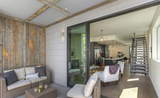 The interiors lead to a large, covered terrace through generous sliding doors.