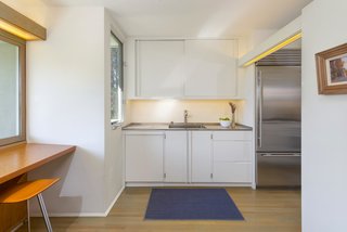 While the updated kitchen is compact, eat-in bar seating is located underneath a large window. 