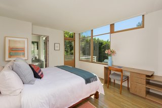 Downstairs, the sunlit master bedroom features an ensuite bath and a door leading to an outside terrace. 