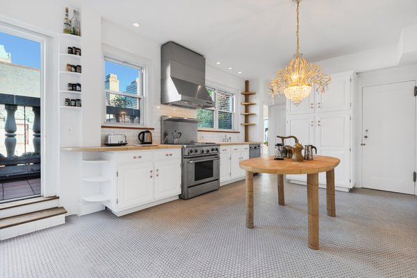 The bright and spacious kitchen features a penny-tiled floor and steps leading out to the wraparound terrace.