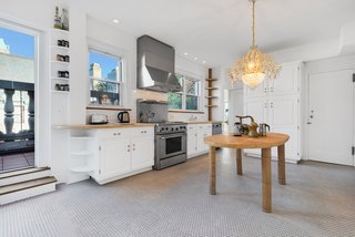 The bright and spacious kitchen features a penny-tiled floor and steps leading out to the wraparound terrace. 