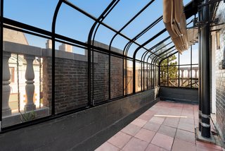 A small greenhouse off the dining room has a retractable canvas roof.