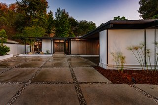 The post-and-beam construction has a dramatic carport entrance which showcases the home's clean, midcentury lines.