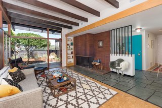 The open-plan living space is anchored by a horizontal brick-inlay fireplace. 