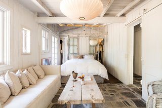 The bedroom has a comfortable, cozy feel—a Nelson bubble lamp gives the space a warm glow. 