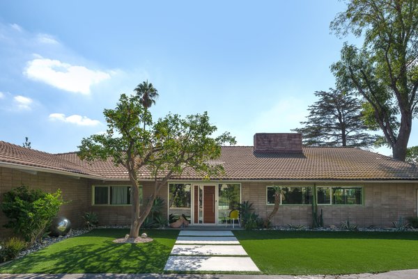 The well-preserved midcentury home sits on a half-acre lot near the Knollwood Country Club in Granada Hills. The lot features a gorgeous outdoor space that includes a sprawling lawn, a covered patio, and a swimming pool and spa.