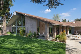 The outdoor space has been landscaped with synthetic turf, as well as drought-tolerant plants.