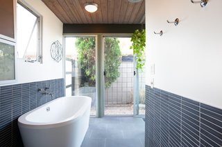 Beautifully tiled, the freestanding soaking tub is an excellent addition to the space. 