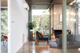 Extensive glazing and a strong wood-burning fireplace define the living room. 