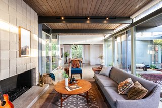 This angle shows the open-plan layout, as well as the living space that blends into the dining area. The exposed wood tongue-in-groove ceilings have been preserved, while additional lighting has been added. 