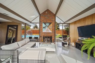 A bold, brick fireplace anchors the living room. 