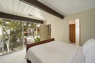 The master bedroom features an ensuite bathroom and opens via sliding doors to the atrium.