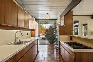 Sliding glass doors in the kitchen open to the outdoors. 