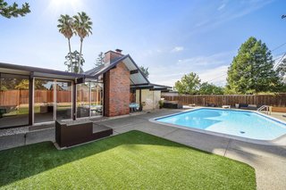 The expansive, enclosed backyard features a gas-heated pool with a diving board. 