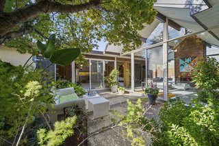 Two walls of glass frame the atrium, filling the home with natural light and a strong sense of the outdoors. 