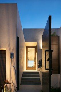 The home is clad in stucco, which is an extremely fire-resistant material. The front door is made from mahogany, which is durable and matches the gate. 